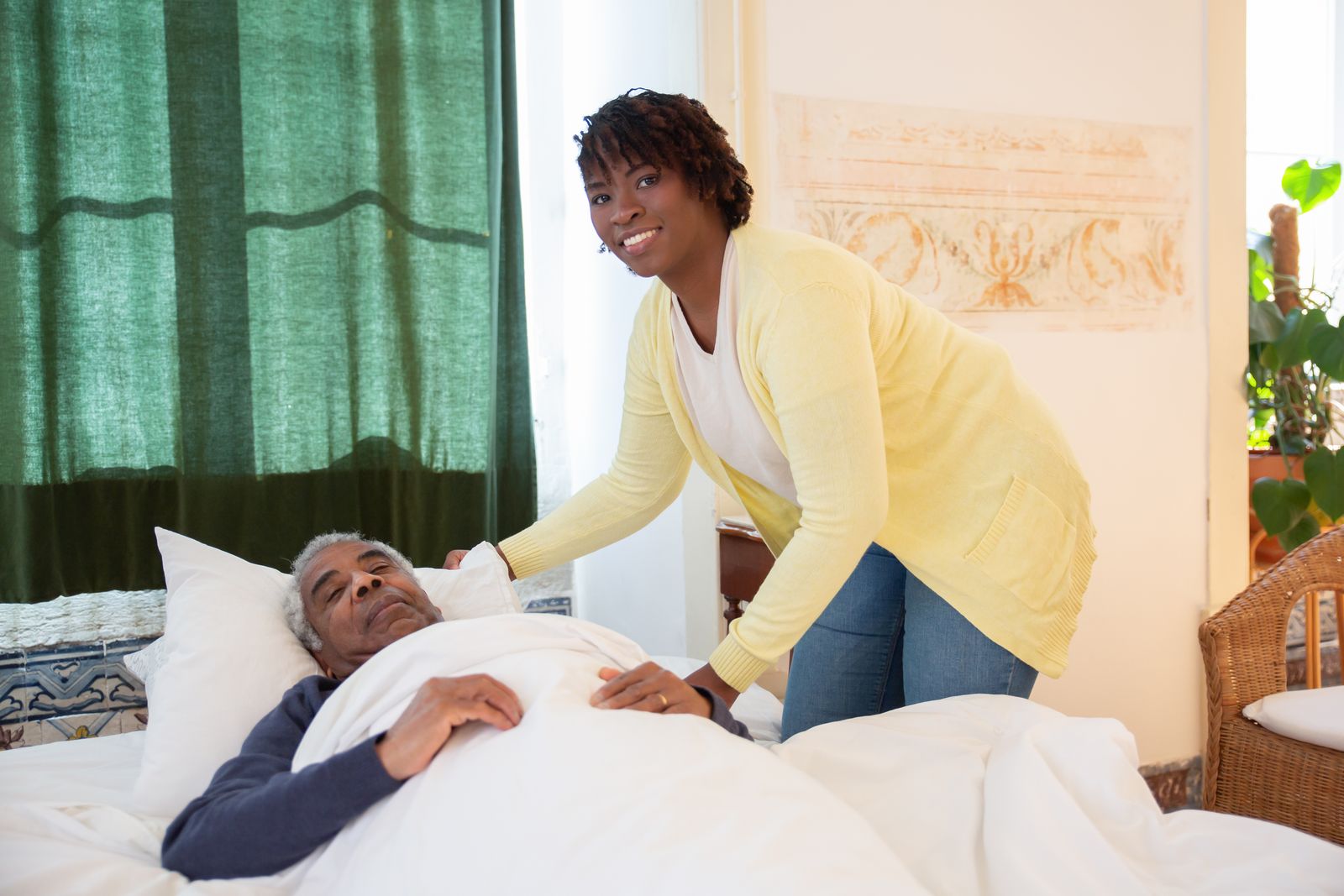 A smiling TrueHeart caregiver attending warmly to a senior client at home